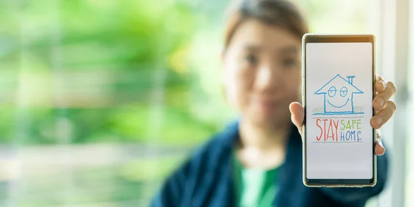 Cihaz kavramını kullanarak evde kalın. Arkadaşınıza, ailenize ya da büyükbabanıza telefon mesajları yollayın. Asyalı kadın, covid-19 virüs salgını sırasında başkaları için sağlık kaygıları çizdiğini göstermektedir..