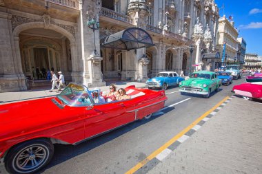 Havana, Küba 16 Aralık 2019: Mutlu turistler tatil zamanlarında Paseo del Prado, El Capitolio ve Havana tarihi şehir merkezi boyunca ünlü renkli Küba taksileriyle taksi turu yapıyorlar.