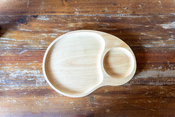 Tahta masada yemek tabağı ve bir fincan kahve.