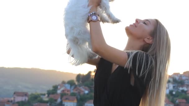 Attrayant heureux blonde femelle tenant et étreignant chien maltais chiot — Video