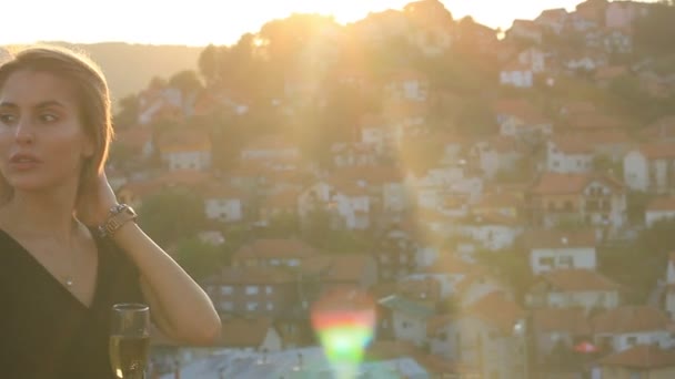 Donna attraente con Champagne Glass sulla terrazza sulla retroilluminazione Golden Hour Sun — Video Stock