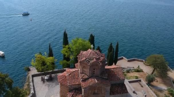 マケドニアのオリード湖の上の崖の聖ヨハネ・カネオ正教会の空中 — ストック動画