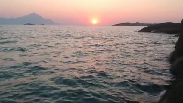 Vista aérea do nascer do sol sobre o mar, voando acima da água e da costa rochosa — Vídeo de Stock