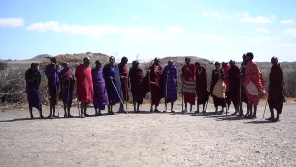 Pomalý pohyb mužů kmene Maasai stojících v barevných tradičních šatech — Stock video