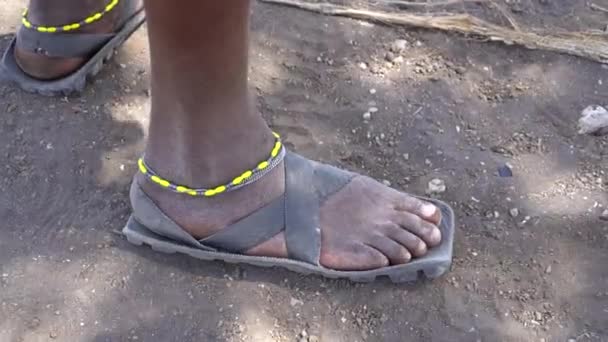 Cierre de pie y zapato hecho de neumático en la pierna masculina. Tribu Maasai, África — Vídeo de stock