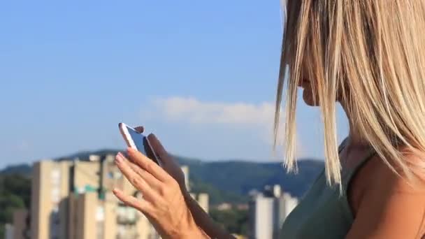 Piękna młoda kobieta z długimi włosami biorąc krajobraz zdjęcie ze smartfonem — Wideo stockowe