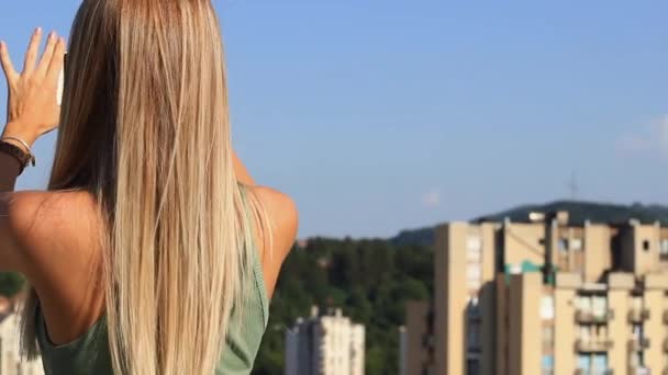 Giovane ragazza bionda Influencer Scattare foto panoramiche della città su smartphone — Video Stock