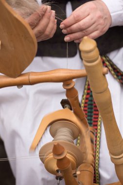 Eller kadının bir çıkrık ile iplik içine yün iplik