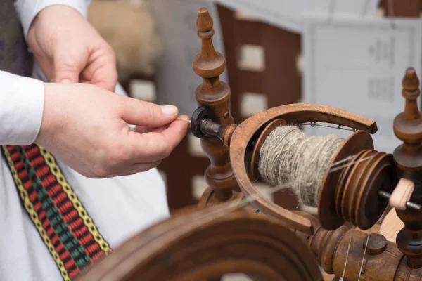 Mani di donna linea di filatura lino con una ruota di filatura — Foto Stock