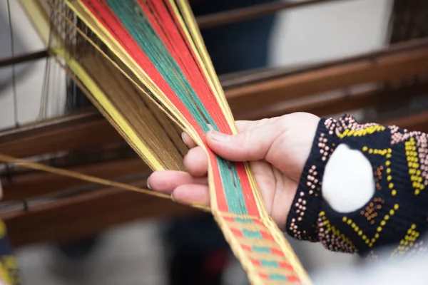 Mani di donna che tessono la tradizionale banda etnica lituana dal lino — Foto Stock