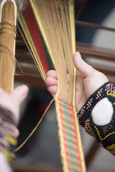 Hände von Frauen, die traditionelle litauische ethnische Bänder aus Leinen weben — Stockfoto