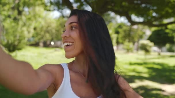 Fiatal, többnemzetiségű női barátok csoportja szórakozik és szelfit készít a parkban egy fényes, napos napon a parkban. — Stock videók