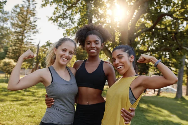 Portret van een Afrikaans-Amerikaanse vrouw die met haar twee verschillende vrienden in het park staat en hun spieren buigt - 3 vrouwen met kracht en vrouw - 3 vrouwen met biceps — Stockfoto