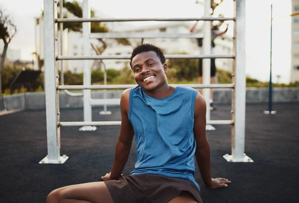 Portrait of a smiling young african american male athlete relaxing after intense workout in the outdoor gym park — 스톡 사진
