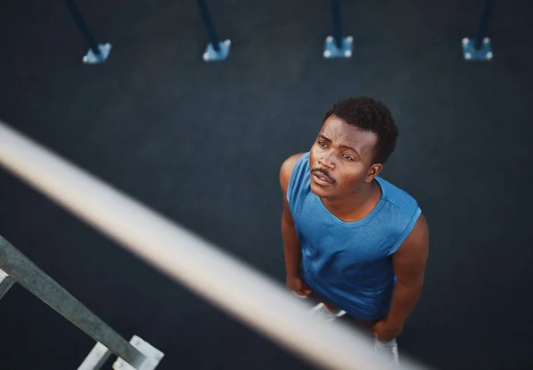 Una vista aérea de un joven atleta afroamericano se prepara para hacer flexiones en la barra horizontal - hombre con miedo al ejercicio —  Fotos de Stock