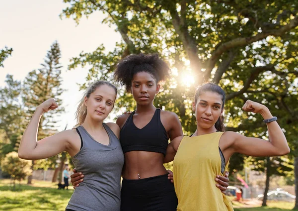 Sportiga friska unga multietniska kvinnliga vänner spänner sina muskler tittar på kameran i parken - stark kvinna skildrar kvinnlig makt — Stockfoto