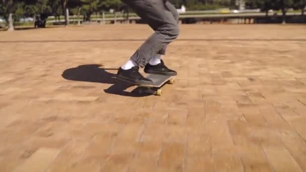 Primo piano di un giovane pattinatore che fa trucchi di skateboard nel parco — Video Stock