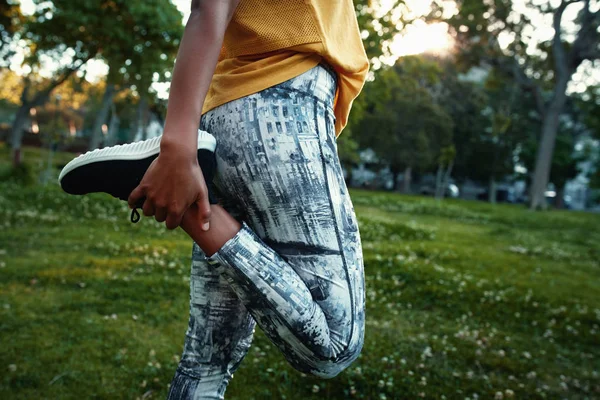 身着运动服的女性特写在公园里伸腿- -女性在跑步前伸展四肢 — 图库照片