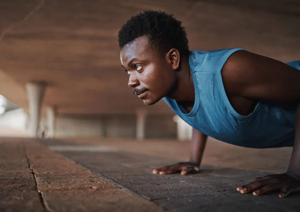 Joven afroamericano deportivo físico hombre haciendo flexiones en el pavimento al aire libre —  Fotos de Stock