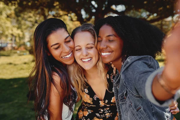 Potret wanita muda tersenyum multirasial berdiri berpose untuk foto bersama-sama kelompok teman-teman mengambil selfie di luar ruangan di taman pada hari yang cerah — Stok Foto