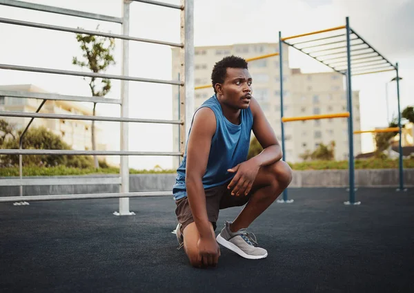 Retrato del joven afroamericano deportista relajándose al aire libre después de entrenar en el parque público de gimnasia —  Fotos de Stock