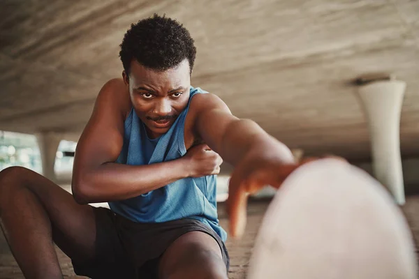 Retrato de um corredor masculino tentando esticar as pernas antes de correr ao ar livre — Fotografia de Stock