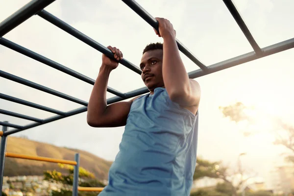 Pemuda berotot atletik african american manusia bekerja di sebuah gym luar ruangan melakukan pull up — Stok Foto