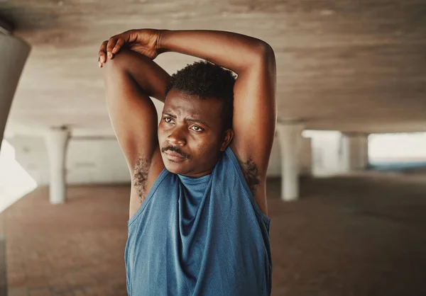 Retrato de um jovem afro-americano estendendo as mãos antes de correr ao ar livre olhando para longe — Fotografia de Stock