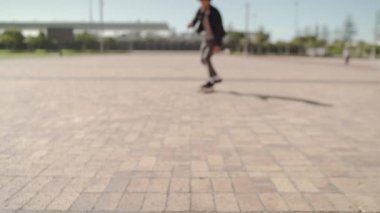 Portrait of a smiling young male skateboarder riding on skateboard towards the camera over the city street , portrait of a skater saying whats up 