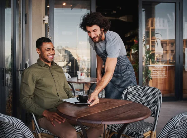 Vrolijke jongeman serveert afro-Amerikaanse klant bij coffeeshop — Stockfoto