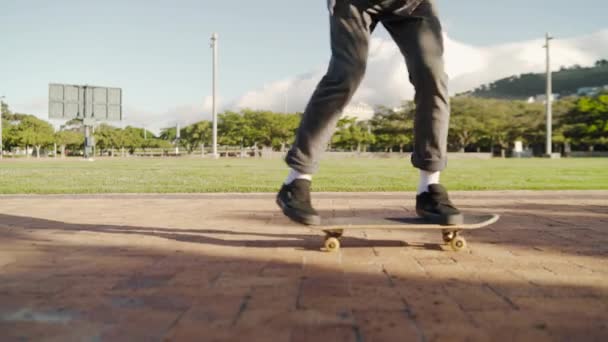 男性スケートボーダーの足は公園でスケートボードでバランスをとる-スケートボーダーは公園でトリックを行う — ストック動画