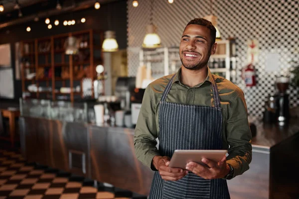 Jovem e alegre proprietário masculino segurando tablet digital enquanto está em pé no café — Fotografia de Stock