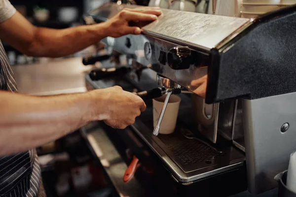 Closeup van mannelijke ober handen maken van koffie uit de machine in cafe — Stockfoto