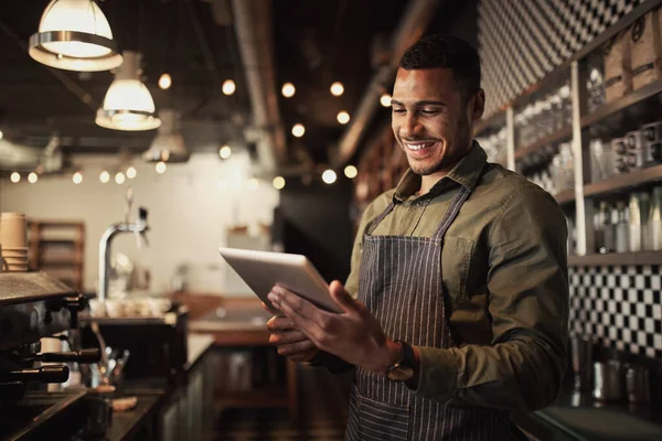 Portret van succesvolle jonge afro-Amerikaanse caféhouder die achter de toonbank staat met behulp van digitale tablet — Stockfoto