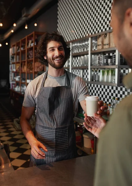Glimlachende volwassen ober het geven van afhaalkoffie aan de man in cafetaria — Stockfoto