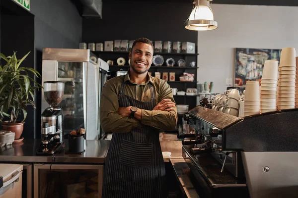 Retrato de un joven camarero sonriente y confiado de pie en el mostrador de la cafetería —  Fotos de Stock