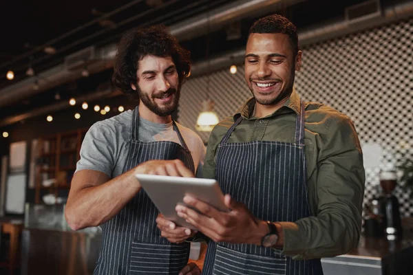 Travailleurs de café multiethniques travaillant ensemble dans un café en utilisant une tablette numérique — Photo