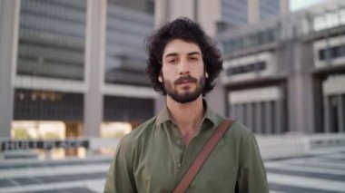 Portrait of confident businessman standing outdoors near office building looking at camera