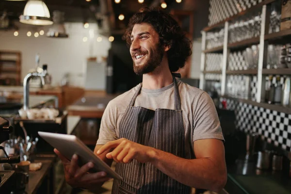 Ritratto di giovane proprietario di caffè caucasico di successo in piedi dietro il bancone utilizzando tablet digitale — Foto Stock