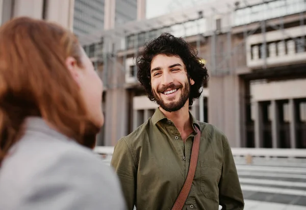 Portrait of successful and laughing business man in conversation with female partner on city street — Stockfoto