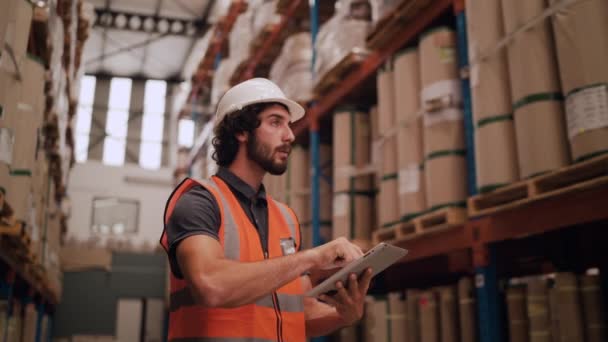 Trabajador de almacén verificando inventario en la sala de stock de una empresa de fabricación en la tableta de pantalla táctil — Vídeos de Stock