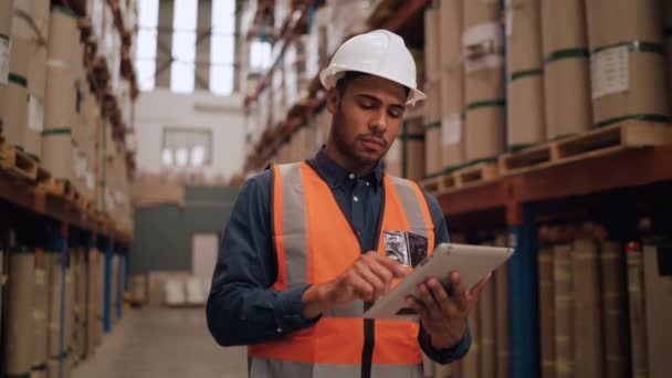Portrét pracovníka skladu s použitím digitálního tabletu při pohledu na skladovací prostory — Stock video