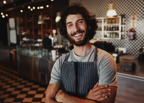 Portret van lachende knappe jonge ober permanent bij koffie shop — Stockfoto