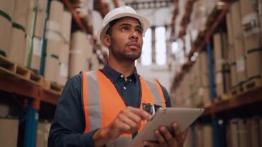 Nakliye şirketinin deposunda tablet bilgisayar kullanan bir erkek işçi ya da üniformalı yönetici.