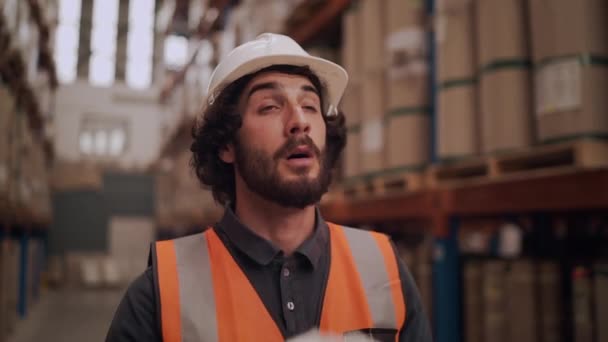 Sjuk allergisk manliga fabriksarbetare i vit hatt och reflekterande jacka står på lager blåser hans rinnande näsa i vävnad — Stockvideo