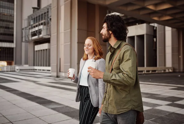 Ділова людина і жінка п'ють каву в розмові на відкритому повітрі під час виходу з будівлі — стокове фото