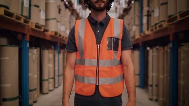 Inclinez-vous devant un jeune ouvrier d'entrepôt ou un superviseur dans un entrepôt souriant et regardant la caméra — Video
