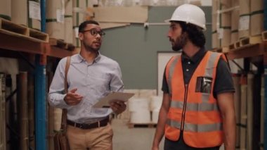 İki çağdaş profesyonel işadamı ve fabrika işçisi atölyede yürürken teknik verileri tartışıyorlar.