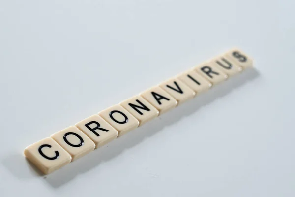 Coronavirus covid-19 spelt on scrabble tiles on white background — Stockfoto
