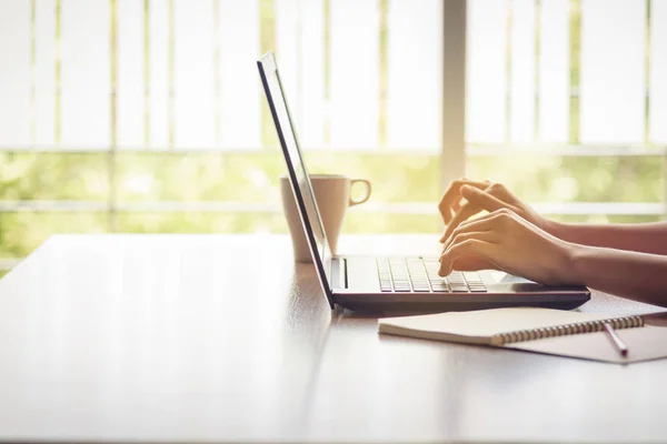 hands typing on laptop on desk, business at work